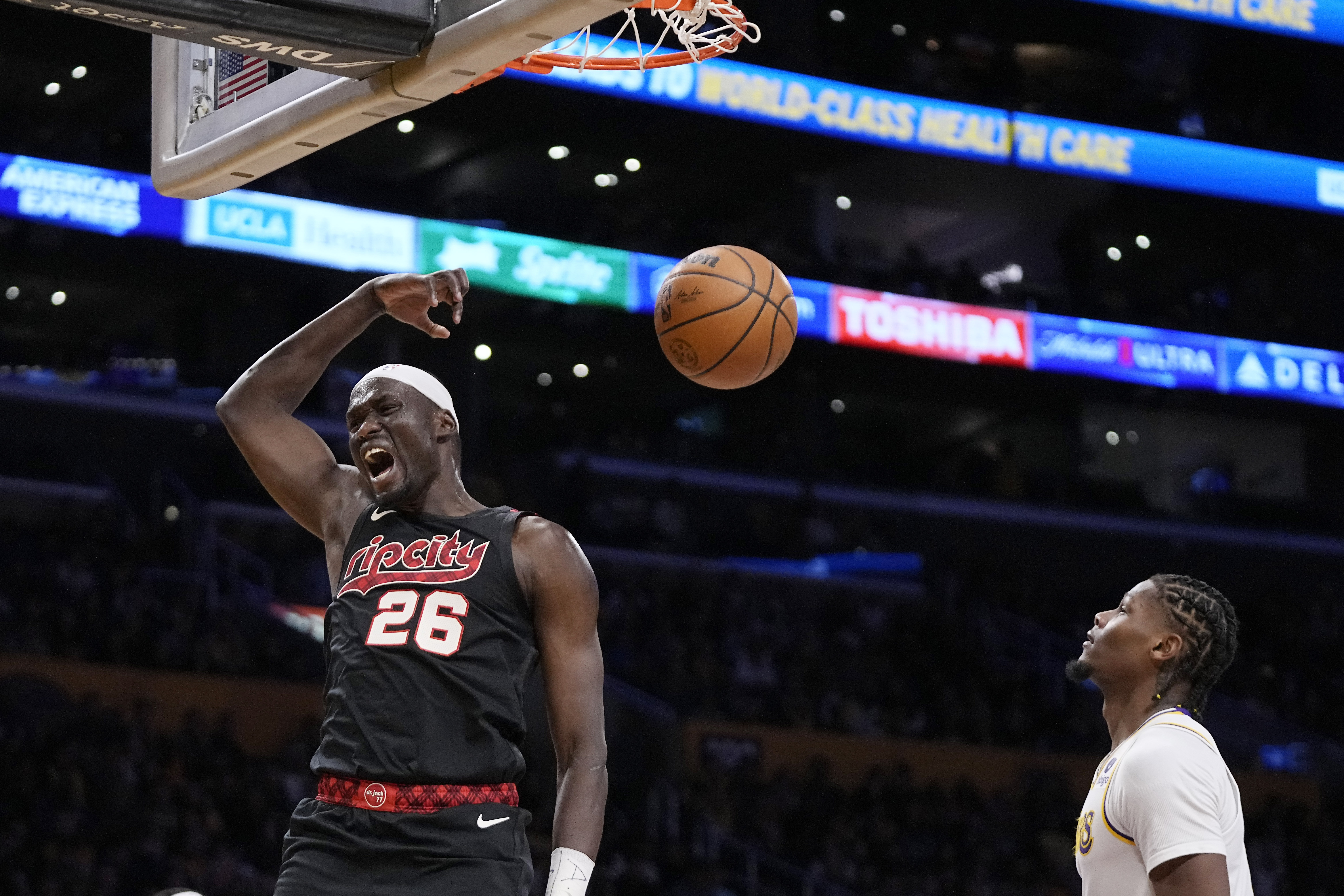 Portland Trail Blazers center Duop Reath, left, dunks as Los Angeles Lakers forward Cam Reddish watches during the second half of an NBA basketball game Sunday, Nov. 12, 2023, in Los Angeles. (AP Photo/Mark J. Terrill) AP